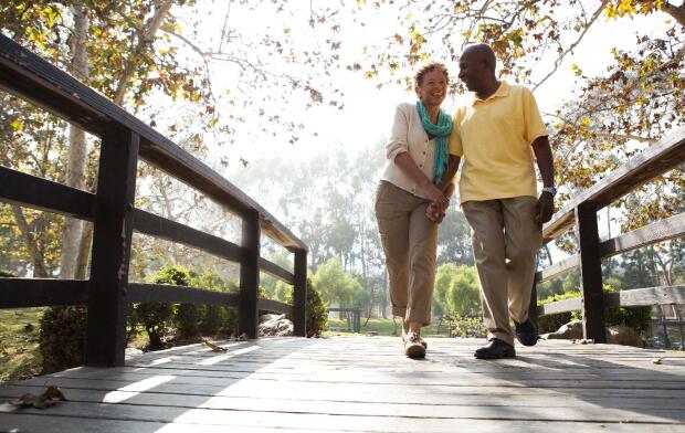 senior couple walking over bridge
