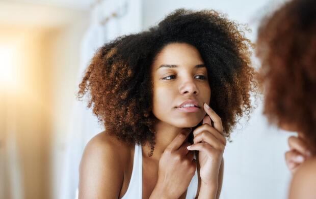 woman looking at face in mirror