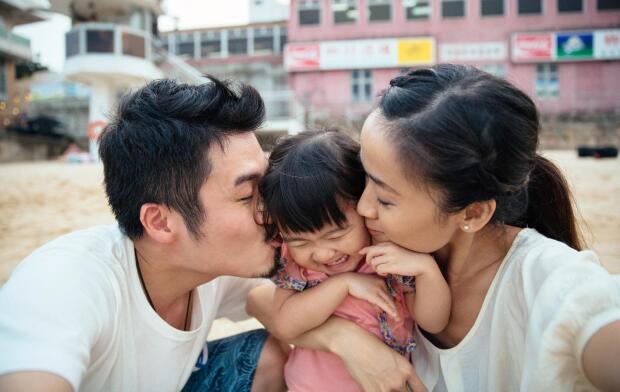 mother and father embracing child