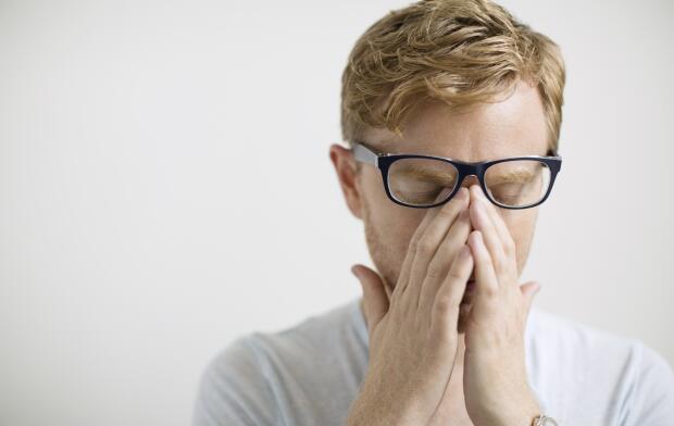 金发碧眼的男人在眼镜下揉眼睛 金发碧眼的男人在眼镜下揉眼睛