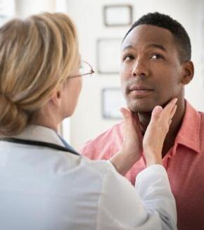 Doctor examining man's neck