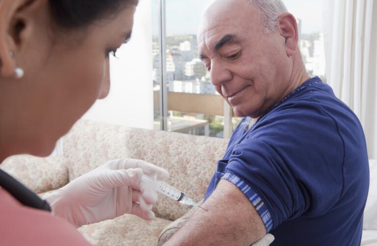 senior man receiving injection from nurse healthcare crm