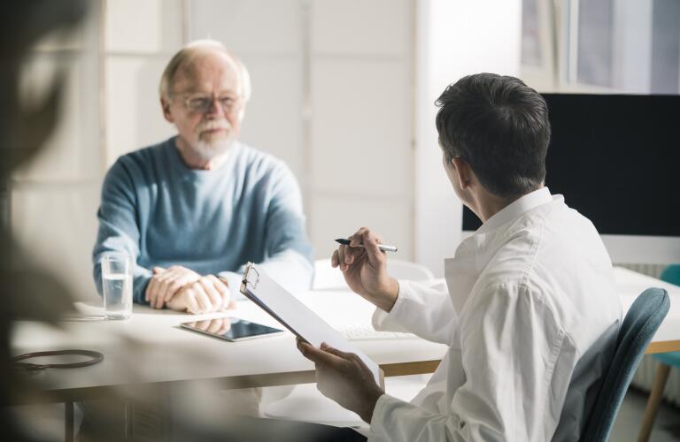 Doctor talking to senior patient in medical practice