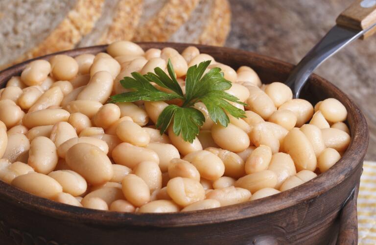 White kidney beans in a brown pot macro and bread