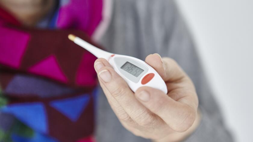 Close up of woman's hand holding thermometer