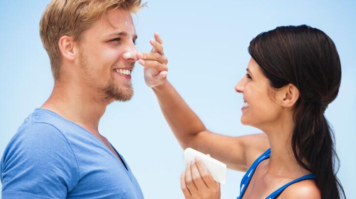 woman-applying-sunscreen-to-man