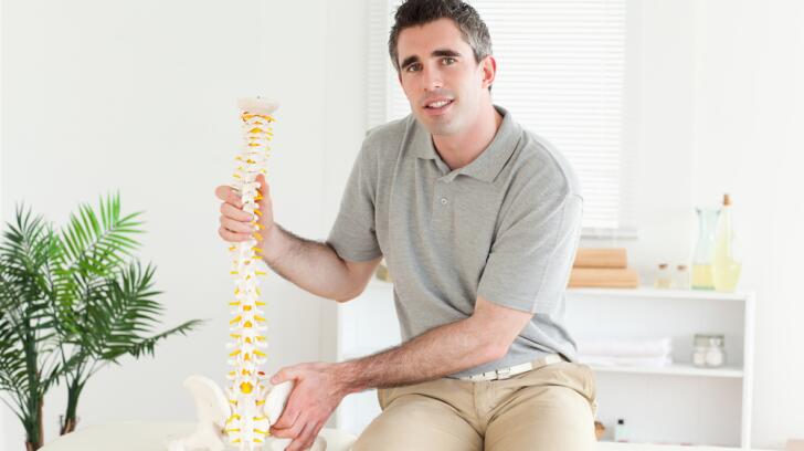 Chiropractor showing spine model