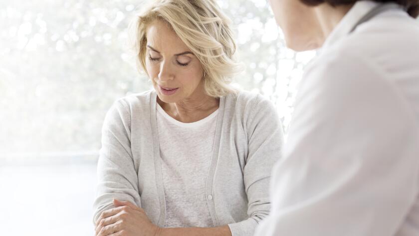 Middle aged Caucasian woman with arm pain at doctor
