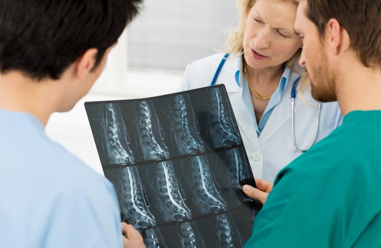 Doctors looking at spine X-ray