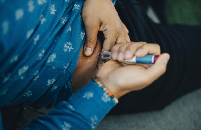 Man injecting insulin into stomach