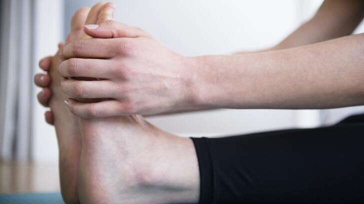 женщина-растяжка-ноги-держась-ступни