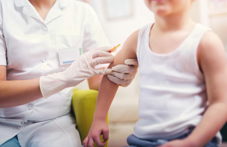 Young Caucasian toddler boy getting vaccine shot in arm
