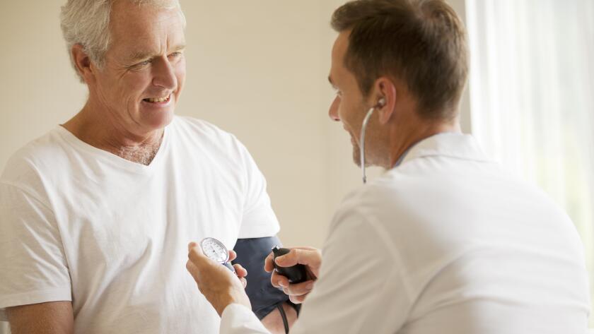 Doctor checking patients blood pressure