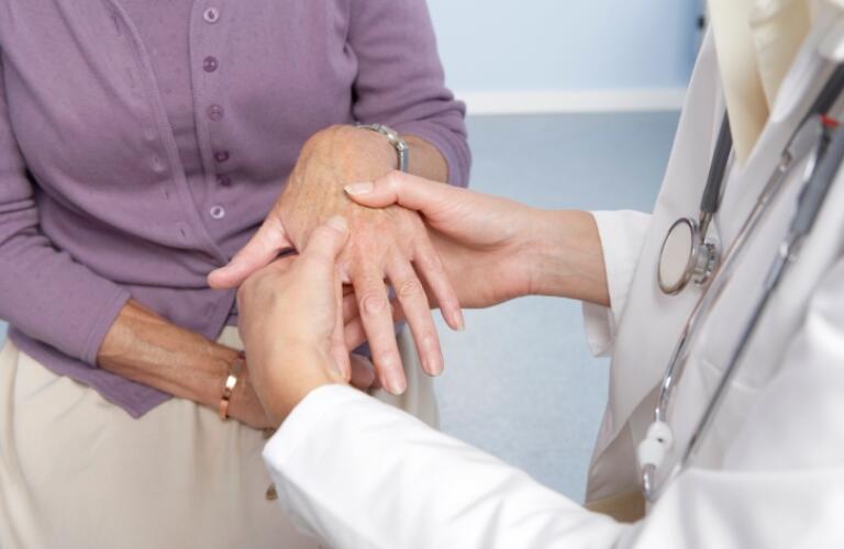 General Practitioner examining patients hand