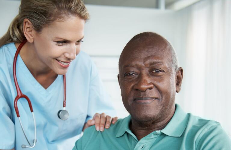 African-man-sitting-in-a-wheelchair-with-his-nurse-standing-beside-him