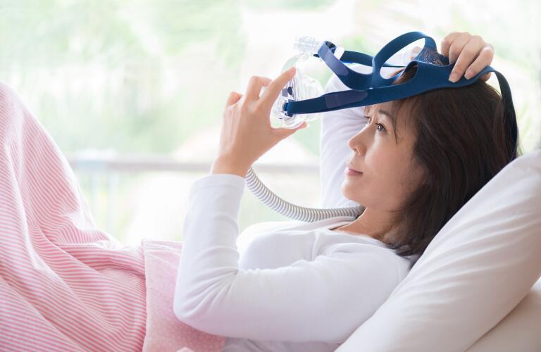 woman trying on cpap mask