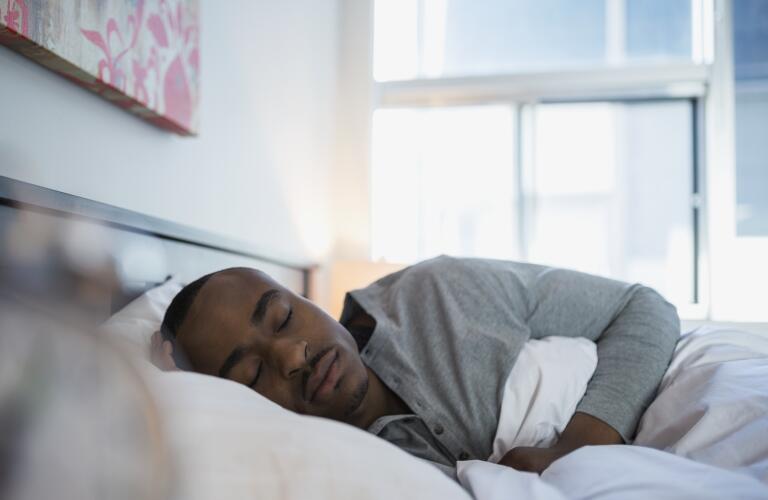 Serene man sleeping in bed in the morning