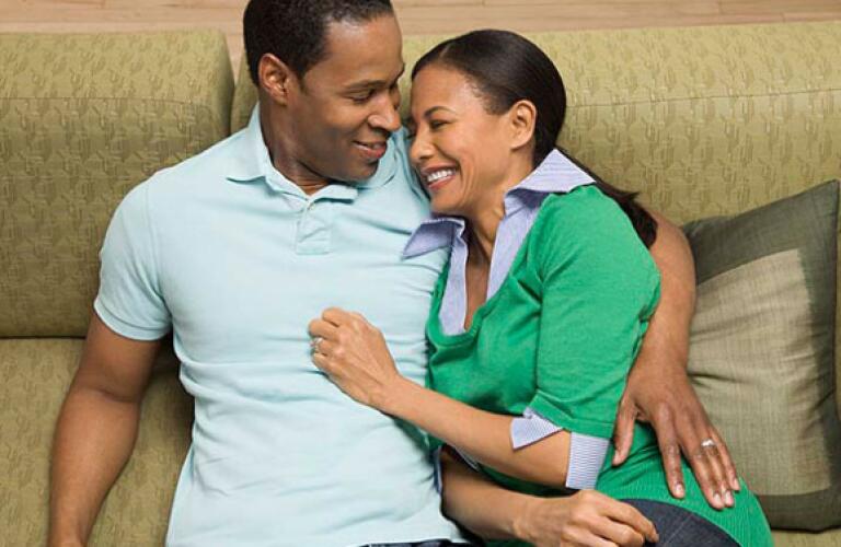 Man and woman on couch smiling