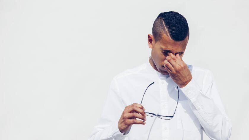 man rubbing his eyes