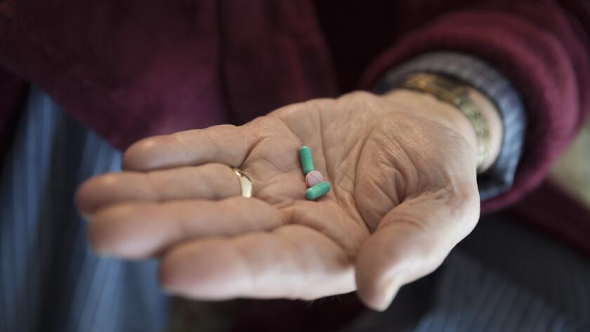 senior-man-holding-pills