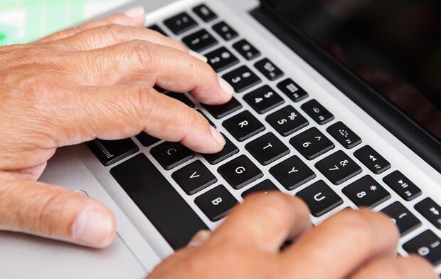 Hands of man on computer keyboard
